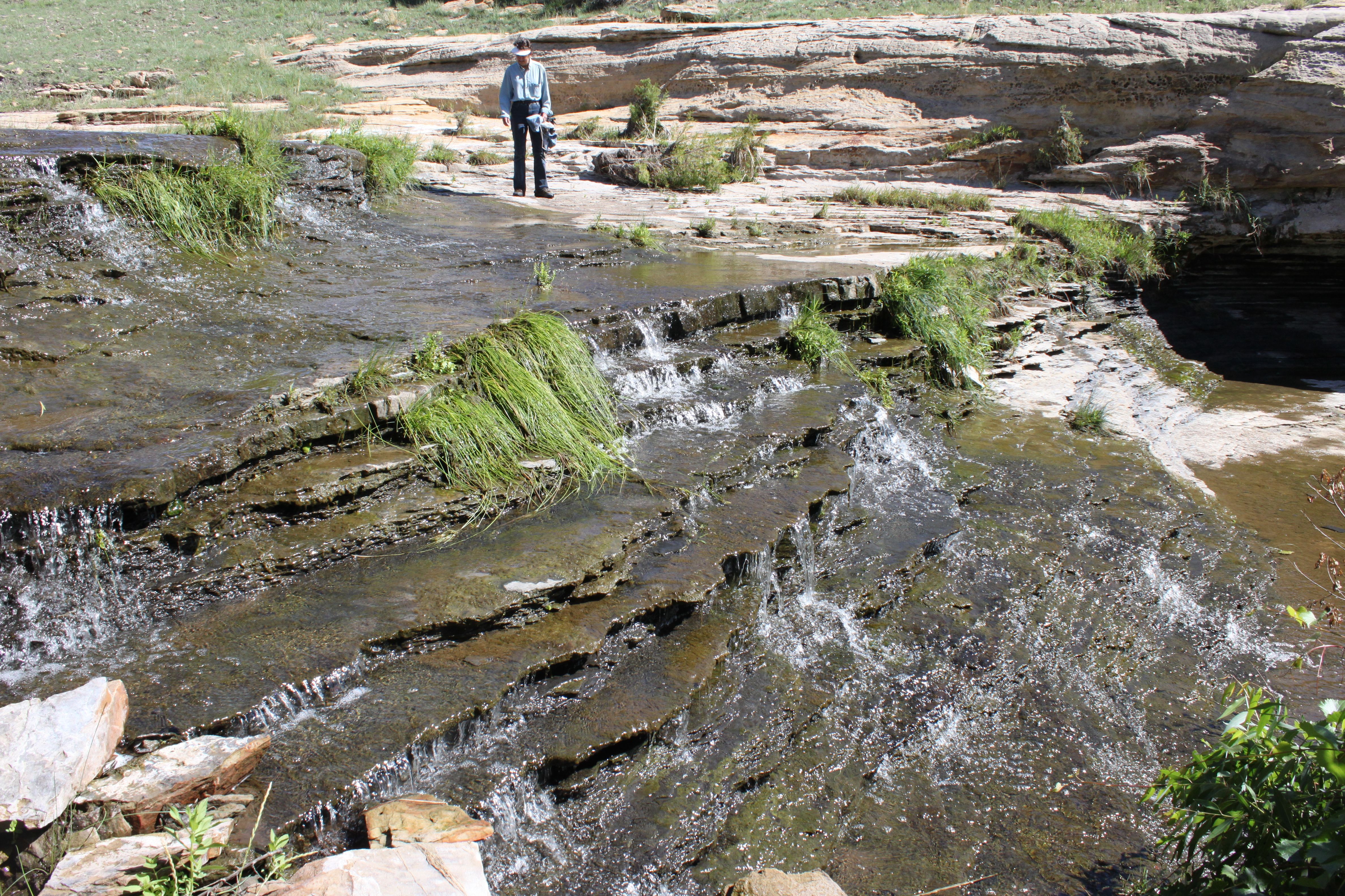 A visitor beside the water and rock ledges of Alamocita Creek